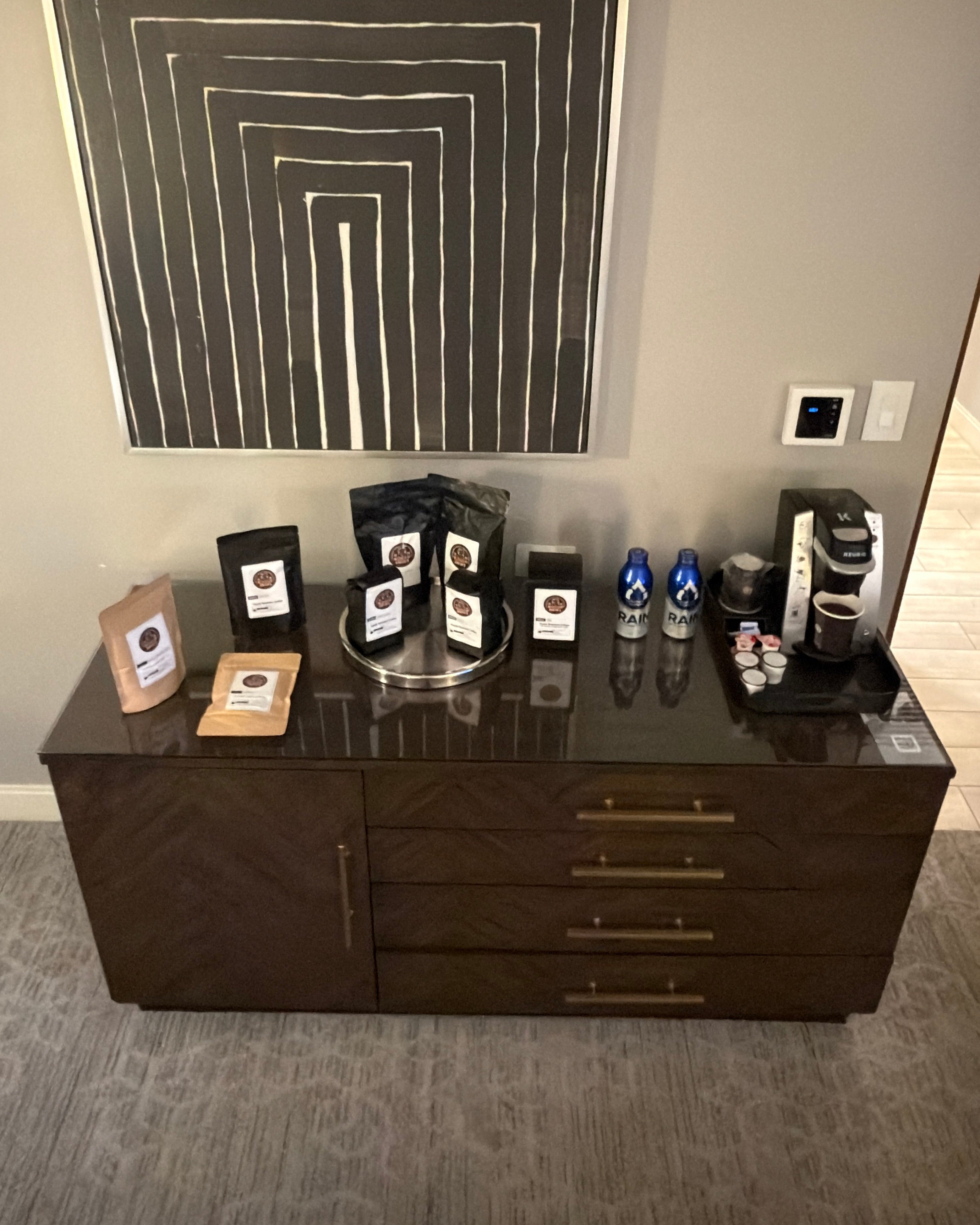Dresser with decorative items against a wall with abstract art